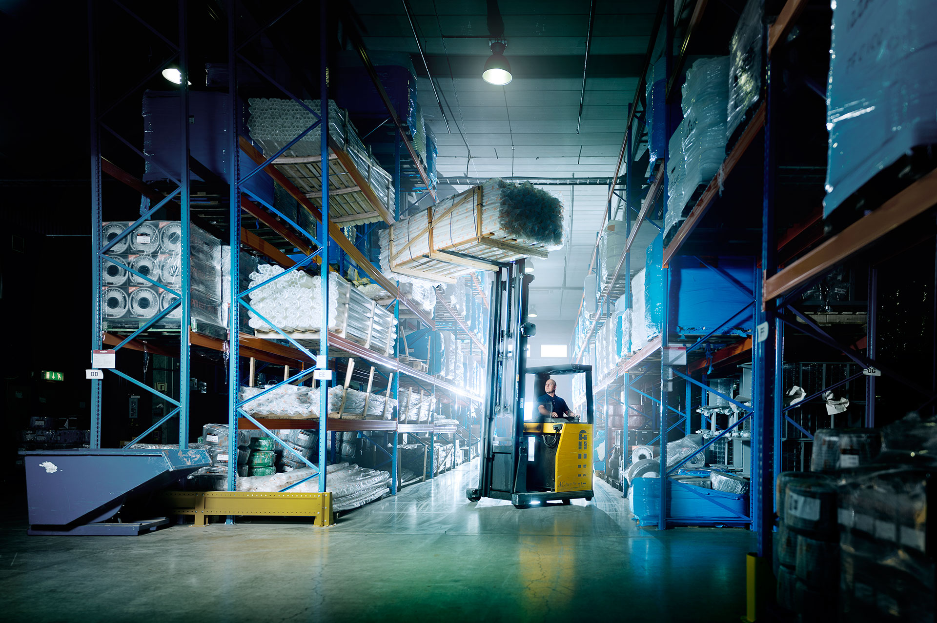 Picture of man operating a forklift truck inside of a warehouse