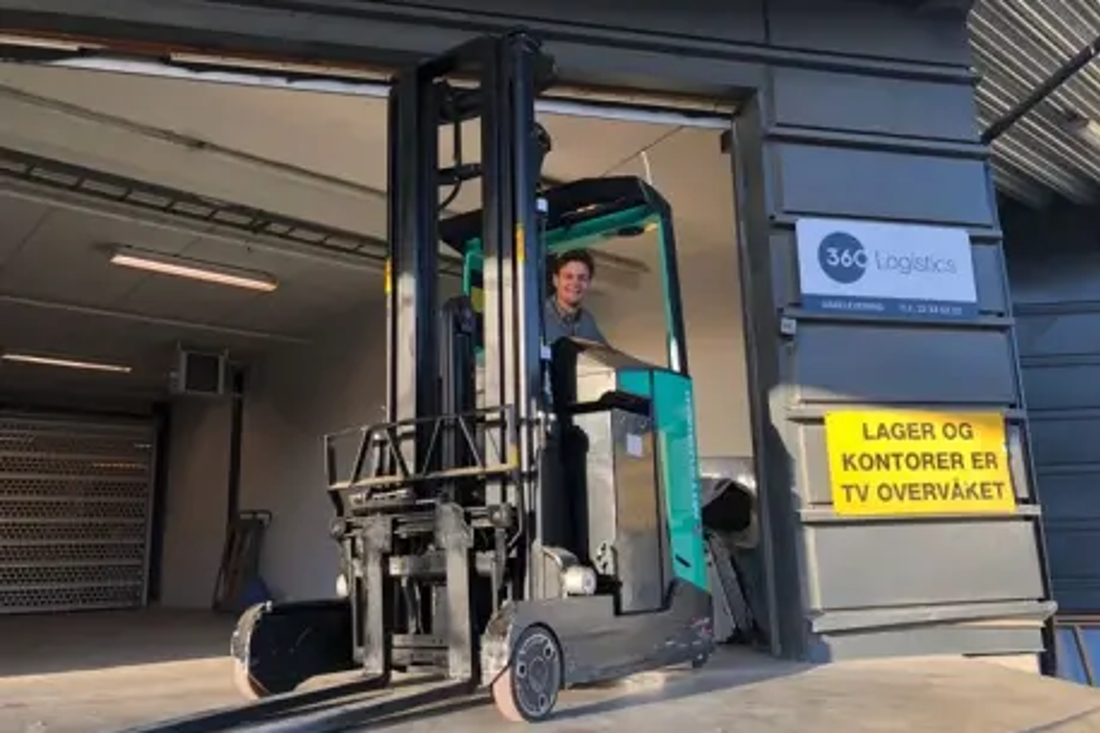 Warehouse worker driving a forklift out of a 360 Logistics facility.