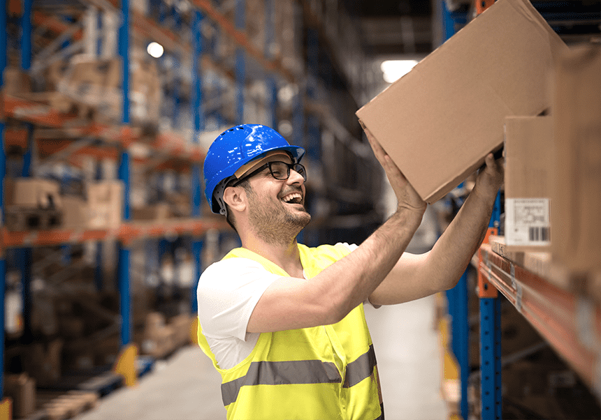 Smiling man that picks a parcel from a warehouse location