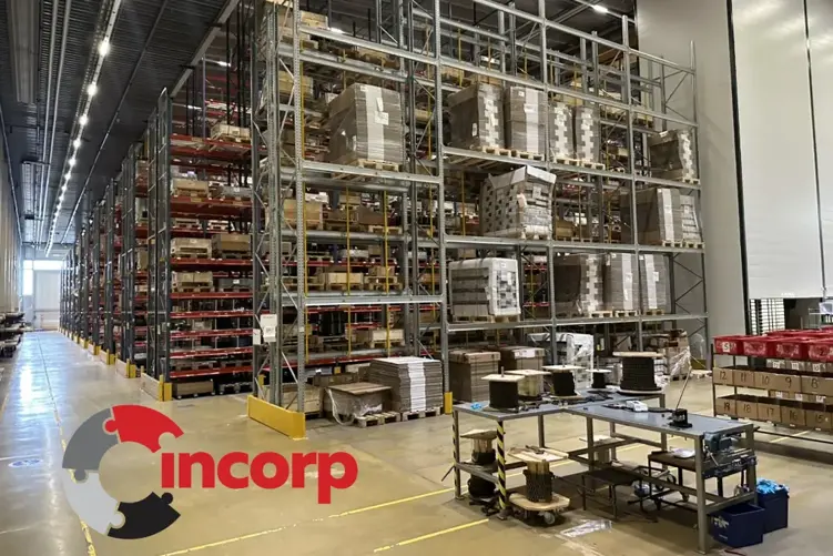 Large warehouse filled with high pallet shelving, workstations, and the incorp logo overlay in bottom left.