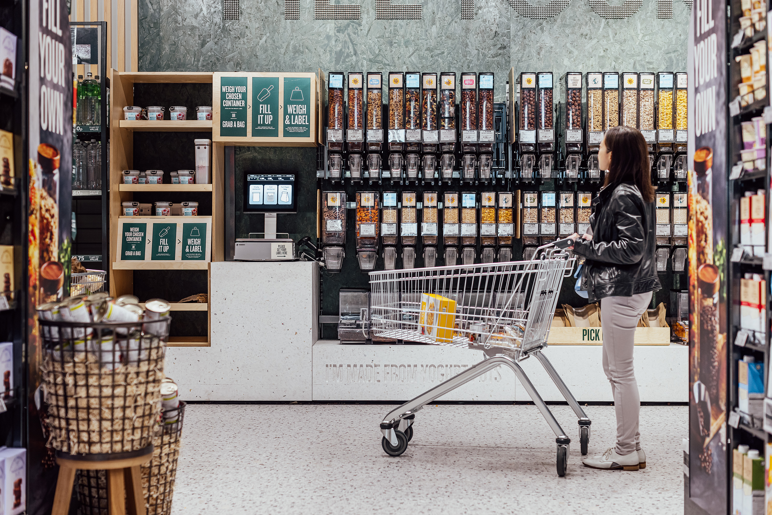 Picture of woman with shopping cart among a bunch of granola dispensers